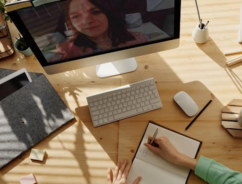 Enhance Your Skills with Online Training: Learn from Anywhere. A person attending an online meeting on a computer, engaging in remote learning or training.