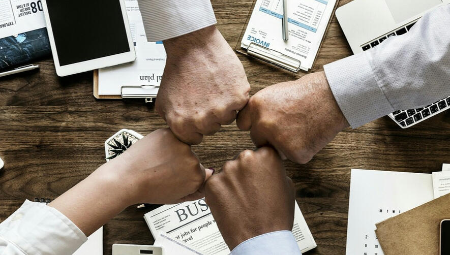 Collaboration and Strategy for Successful Trust and Foundation Fundraising. Group of hands fist pumping, symbolising collaboration and successful fundraising strategies.